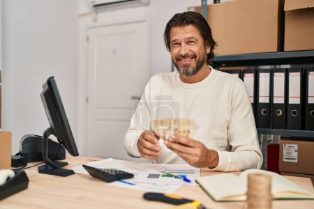 Foto de Hombre de mediana edad comercio electrónico trabajador de negocios contando denmark billetes de coronas en la oficina - Imagen libre de derechos