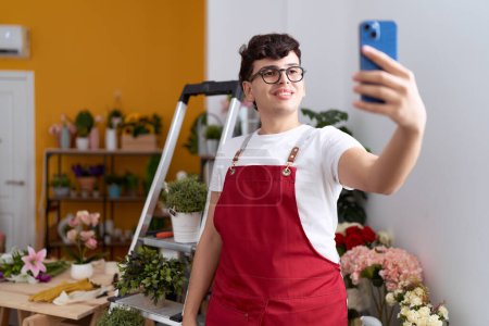 Foto de Florista hombre no binario hacer selfie por teléfono inteligente en la tienda de flores - Imagen libre de derechos