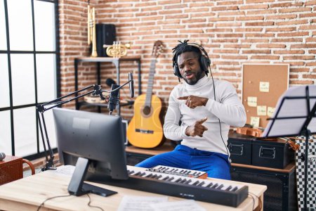 Téléchargez les photos : Musicienne afro-américaine jouant du clavier de piano et dansant au studio de musique - en image libre de droit