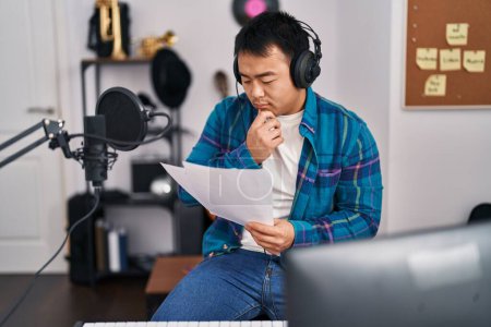 Photo for Young chinese man singer singing song at music studio - Royalty Free Image
