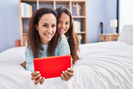 Téléchargez les photos : Woman and girl mother and daughter using touchpad at bedroom - en image libre de droit