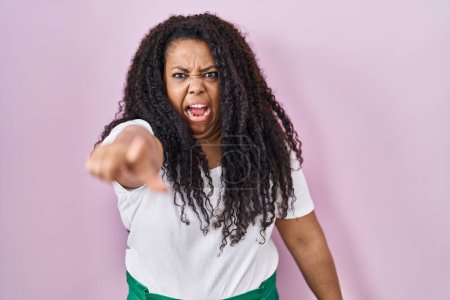 Photo for Plus size hispanic woman standing over pink background pointing displeased and frustrated to the camera, angry and furious with you - Royalty Free Image