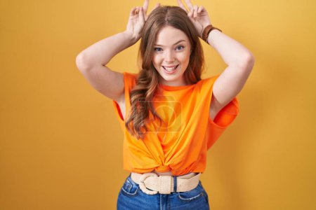 Téléchargez les photos : Caucasian woman standing over yellow background posing funny and crazy with fingers on head as bunny ears, smiling cheerful - en image libre de droit