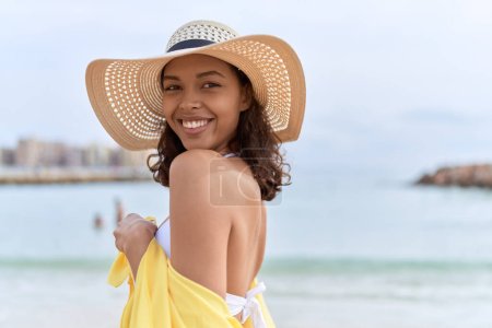 Téléchargez les photos : Young african american woman smiling confident wearing summer hat and bikini at beach - en image libre de droit