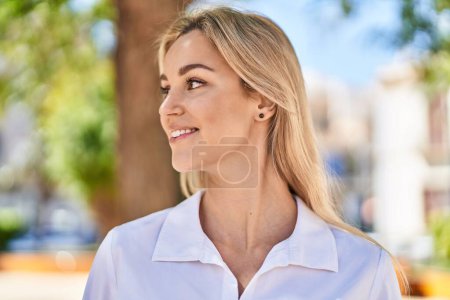 Téléchargez les photos : Young blonde woman smiling confident looking to the side at park - en image libre de droit