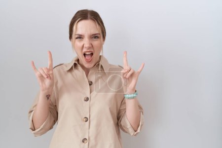 Photo for Young caucasian woman wearing casual shirt shouting with crazy expression doing rock symbol with hands up. music star. heavy music concept. - Royalty Free Image