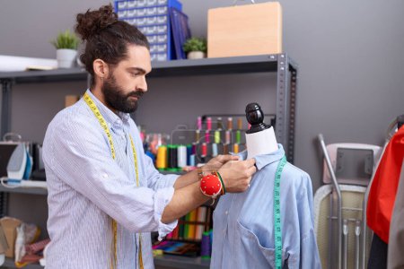 Photo for Young hispanic man tailor standing by manikin working at atelier - Royalty Free Image