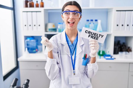 Photo for Young beautiful woman working on cruelty free laboratory screaming proud, celebrating victory and success very excited with raised arms - Royalty Free Image