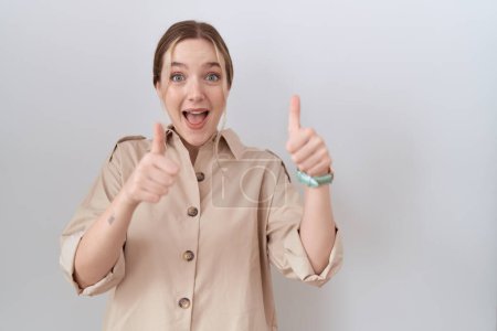 Foto de Mujer caucásica joven con camisa casual aprobando hacer gesto positivo con la mano, pulgares arriba sonriendo y feliz por el éxito. gesto ganador. - Imagen libre de derechos