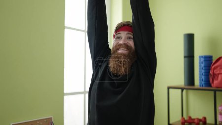 Foto de Young redhead man warming up at sport center - Imagen libre de derechos