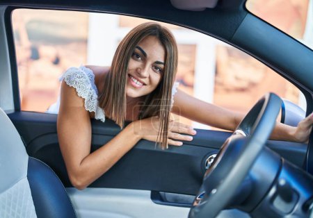 Téléchargez les photos : Young beautiful hispanic woman smiling confident leaning on car door at street - en image libre de droit