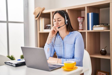 Photo for Young brunette woman wearing call center agent headset serious face thinking about question with hand on chin, thoughtful about confusing idea - Royalty Free Image