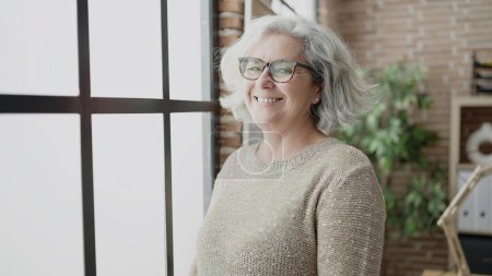 Téléchargez les photos : Middle age woman with grey hair business worker smiling confident at office - en image libre de droit