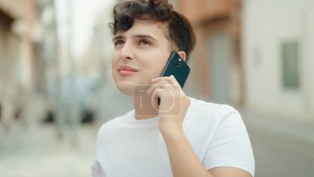 Téléchargez les photos : Non binary man smiling confident talking on smartphone at street - en image libre de droit