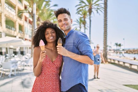Foto de Man and woman couple smiling confident using smartphone at seaside - Imagen libre de derechos