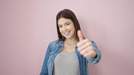 Téléchargez les photos : Jeune belle femme hispanique souriant confiant faire ok signe avec le pouce vers le haut sur fond rose isolé - en image libre de droit