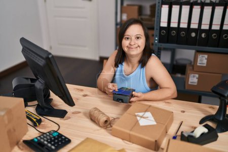 Foto de Síndrome de Down mujer comercio electrónico trabajador de negocios utilizando tarjeta de crédito y teléfono de datos en la oficina - Imagen libre de derechos