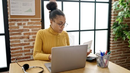 Téléchargez les photos : Jeune femme afro-américaine travailleuse d'affaires lisant des documents au bureau - en image libre de droit