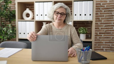 Téléchargez les photos : Middle age woman with grey hair business worker using laptop working at office - en image libre de droit