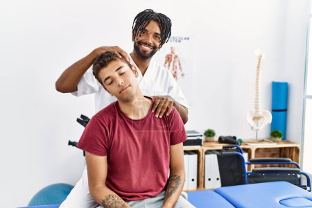 Foto de Dos hombres fisioterapeuta y paciente que tiene sesión de rehabilitación estirando el cuello en la clínica - Imagen libre de derechos