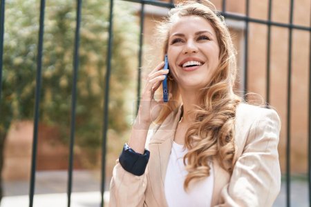 Téléchargez les photos : Jeune femme blonde souriant confiant parler sur le smartphone au parc - en image libre de droit