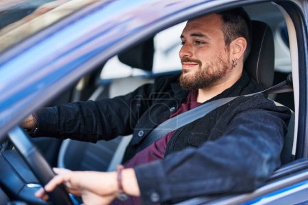 Téléchargez les photos : Young hispanic man smiling confident driving car at street - en image libre de droit