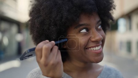 Photo for African american woman smiling confident listening audio message by the smartphone at street - Royalty Free Image