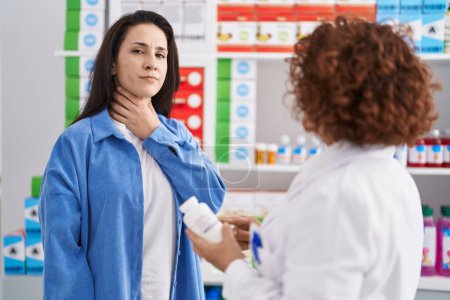 Téléchargez les photos : Deux femmes pharmacien et client prescrivent des pilules pour la douleur à la gorge à la pharmacie - en image libre de droit