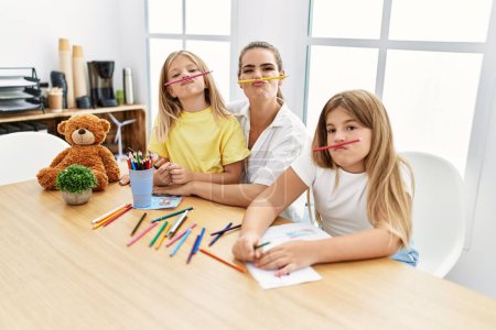 Photo for Mother and daughters with funny expression drawing at home - Royalty Free Image