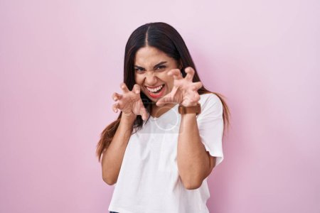 Photo for Young arab woman standing over pink background smiling funny doing claw gesture as cat, aggressive and sexy expression - Royalty Free Image
