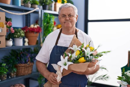 Photo for Middle age grey-haired man florist holding bouquet of flowers at florist - Royalty Free Image