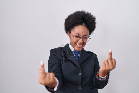 Foto de Beautiful african woman with curly hair wearing business jacket and glasses showing middle finger doing fuck you bad expression, provocation and rude attitude. screaming excited - Imagen libre de derechos