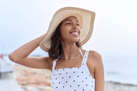 Téléchargez les photos : Young african american woman wearing summer hat looking to the side at seaside - en image libre de droit