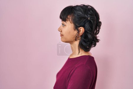 Photo for Young beautiful woman standing over pink background looking to side, relax profile pose with natural face with confident smile. - Royalty Free Image