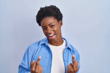 Téléchargez les photos : African american woman standing over blue background showing middle finger doing fuck you bad expression, provocation and rude attitude. screaming excited - en image libre de droit