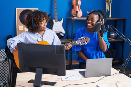 Téléchargez les photos : African american women musicians singing song playing classical guitar at music studio - en image libre de droit