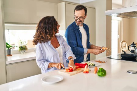 Photo for Middle age hispanic couple smiling confident cooking at kitchen - Royalty Free Image