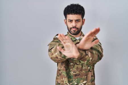 Téléchargez les photos : Arabe portant camouflage uniforme de l'armée expression de rejet traversant les bras et les paumes faisant signe négatif, visage en colère - en image libre de droit