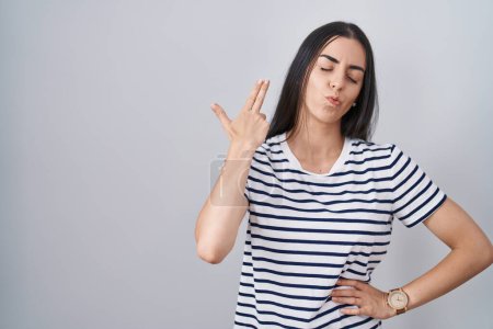 Foto de Young brunette woman wearing striped t shirt shooting and killing oneself pointing hand and fingers to head like gun, suicide gesture. - Imagen libre de derechos