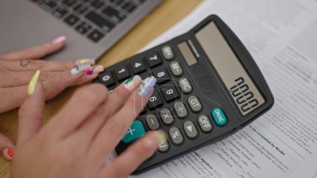Téléchargez les photos : Young blonde woman using laptop and calculator accounting at office - en image libre de droit
