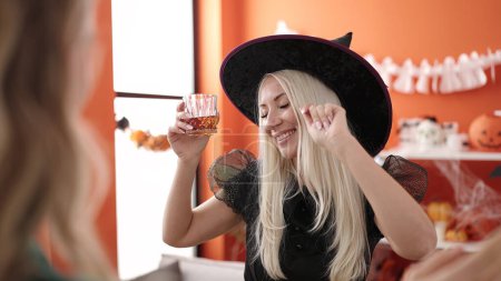 Photo for Young blonde woman having halloween party drinking whisky dancing at home - Royalty Free Image