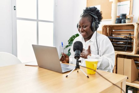 Téléchargez les photos : Jeune diffuseuse afro-américaine souriante confiante travaillant au studio de radio - en image libre de droit