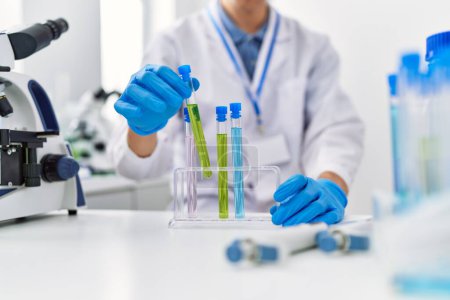 Téléchargez les photos : Young blond man scientist holding test tube at laboratory - en image libre de droit