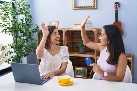Photo for Two women mother and daughter high five with hands raised up at home - Royalty Free Image