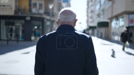 Téléchargez les photos : Senior debout vers l'arrière dans la rue - en image libre de droit