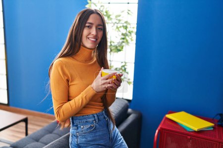 Téléchargez les photos : Jeune belle femme hispanique buvant du café debout à la maison - en image libre de droit