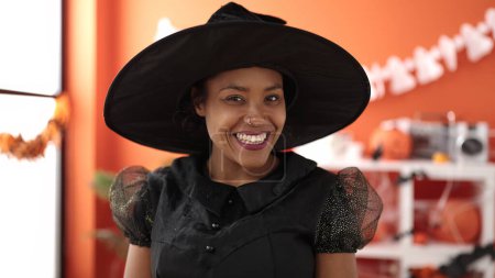 Téléchargez les photos : African american woman wearing witch costume having halloween party at home - en image libre de droit