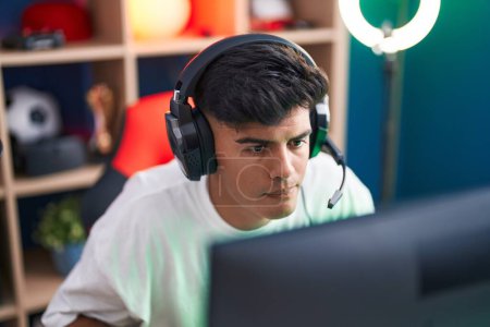 Photo for Young hispanic man streamer playing video game using computer at gaming room - Royalty Free Image