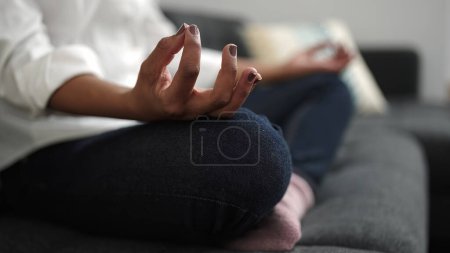 Photo for African american woman doing yoga exercise sitting on sofa at home - Royalty Free Image