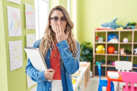 Photo for Young caucasian woman working as teacher at kindergarten covering mouth with hand, shocked and afraid for mistake. surprised expression - Royalty Free Image